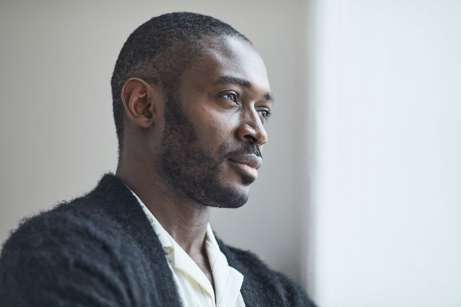 Portrait de profil d'un homme africain pensif regardant vers la lumière, expression déterminée