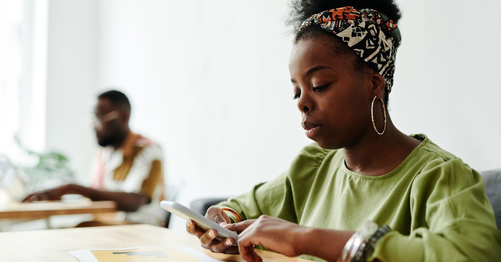 Jeune femme africaine en train d'écrire sur son téléphone