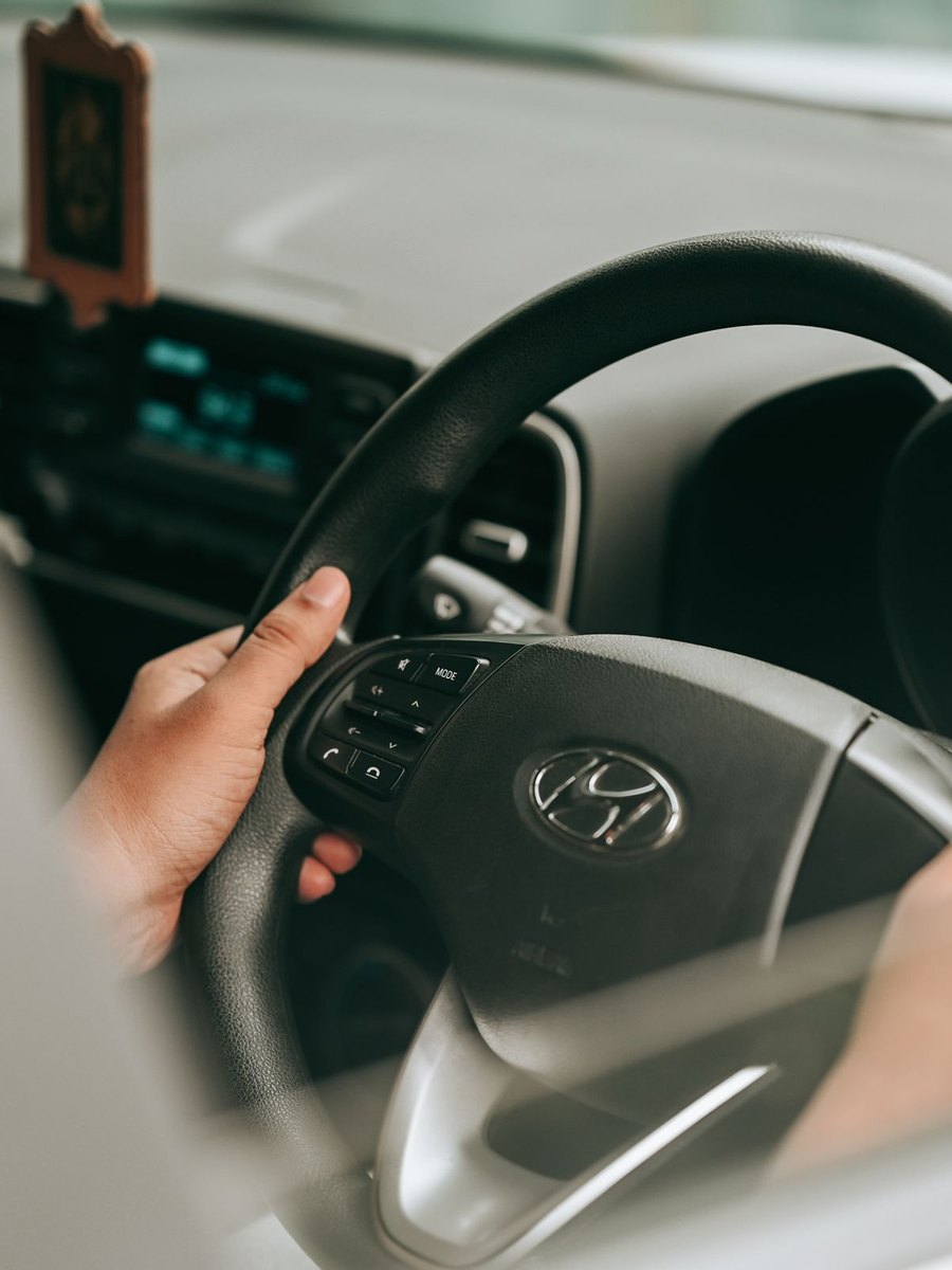 Mains posées sur le volant d'une voiture en mouvement